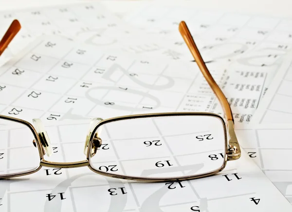 Glasögon på kalendersidorna — Stockfoto