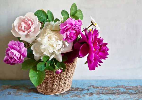 Mand met bloemen op een houten tafel — Stockfoto