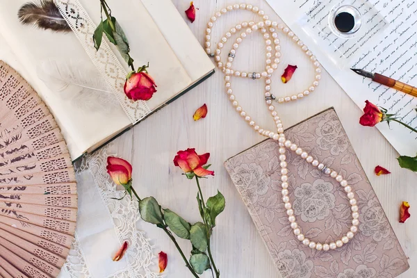 Old books, roses and accessories for writing. — Stock Photo, Image