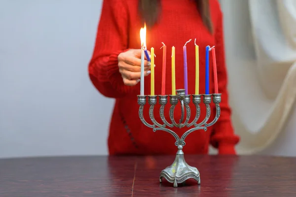 Židovská žena osvětlení Chanuka svíčky v menorah. — Stock fotografie