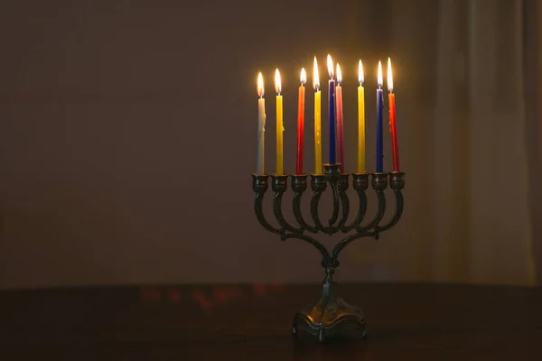 Jüdischer Feiertag Chanukka Hintergrund mit Menora und bunten brennenden Kerzen. — Stockfoto