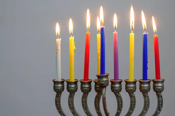 Joodse vakantie Chanoeka achtergrond met menorah en kleurrijke brandende kaarsen. — Stockfoto