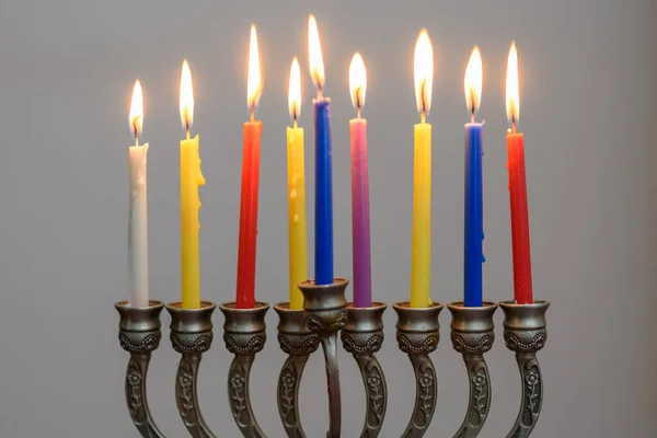Jüdischer Feiertag Chanukka Hintergrund mit Menora und bunten brennenden Kerzen. — Stockfoto