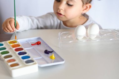 Mutlu Paskalyalar. Paskalya yumurtalarını boyayan komik küçük kız. Mutlu çocuk Paskalya için hazırlanıyor..