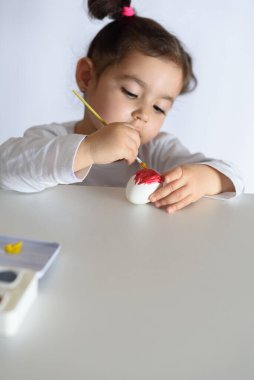 Mutlu Paskalyalar. Paskalya yumurtalarını boyayan komik küçük kız. Mutlu çocuk Paskalya için hazırlanıyor..