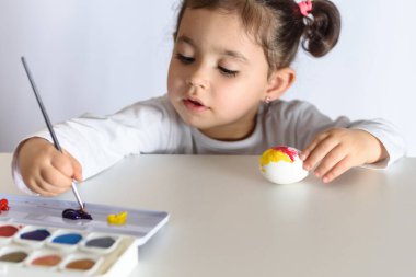 Mutlu Paskalyalar. Paskalya yumurtalarını boyayan komik küçük kız. Mutlu çocuk Paskalya için hazırlanıyor..