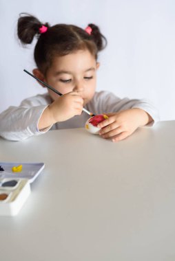 Mutlu Paskalyalar. Paskalya yumurtalarını boyayan komik küçük kız. Mutlu çocuk Paskalya için hazırlanıyor..