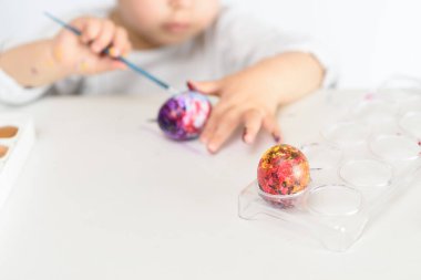 Mutlu Paskalyalar. Paskalya yumurtalarını boyayan komik küçük kız. Mutlu çocuk Paskalya için hazırlanıyor..