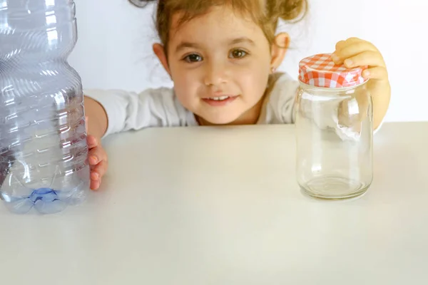 Child Pushing Plastic Bottle Holding Glass Jar Plastic Containers Yes — Stock Photo, Image