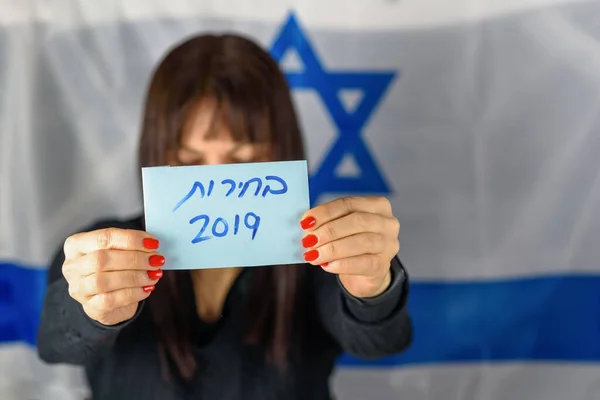Вибори в єврейському тексті 2019 року на голосуванні паперу над дерев'яною дошкою з конфетті фоном. — стокове фото