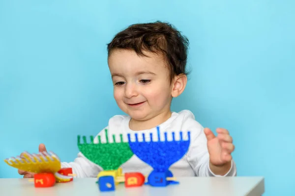 Єврейський хлопчик грає з дрейдлом і папером блискучі меню вдома.. — стокове фото