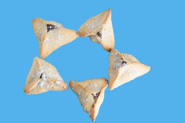Mavi arkaplanda izole edilmiş Hamantaschen kurabiyeleri.