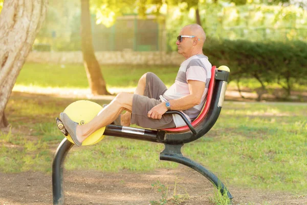 Yaşlı adam spor salonunda spor malzemeleriyle çalışıyor..