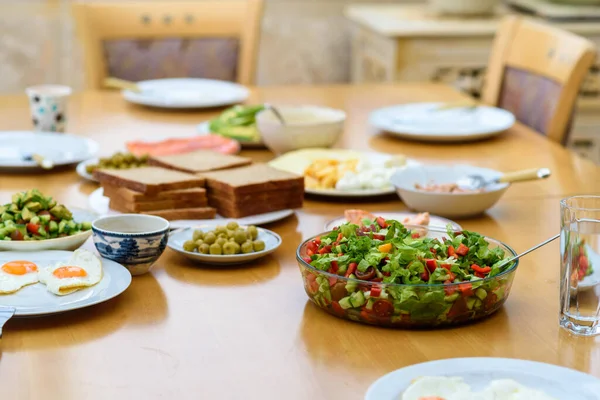 Servindo de ovos, pão e salada de legumes frescos em mesa de madeira, alimentos saudáveis e orgânicos, café da manhã com amigos — Fotografia de Stock