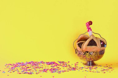 Hammantaschen kurabiyeli Purim bayramı konsepti veya sarı arkaplanlı hamans kulağı.