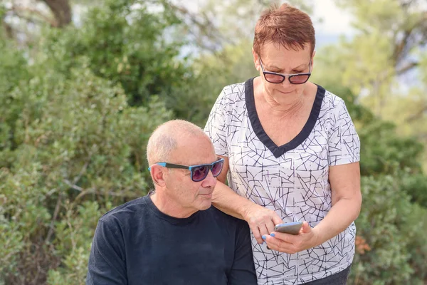 Стильна старша пара в природі використовуючи смартфон . — стокове фото