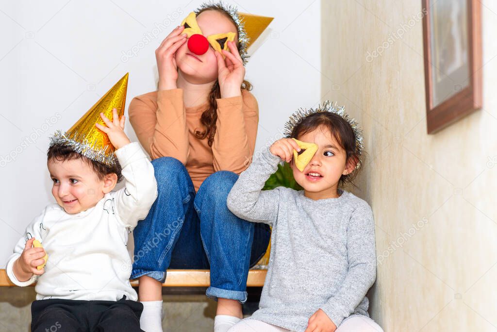 Three kids celebrating Carnival together at home.