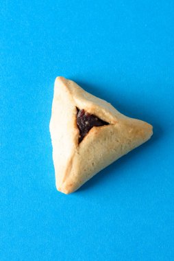 Bir Hamentashen, Ozen Haman, Purim kurabiyesi Yahudi bayramı için mavi arka planda..