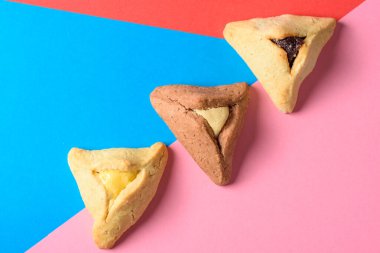 Hamantash dolgulu kurabiye. Kırmızı ve mavi arka planda Yahudi bayramı Purim 'i için üçgen biçiminde tanınabilir..