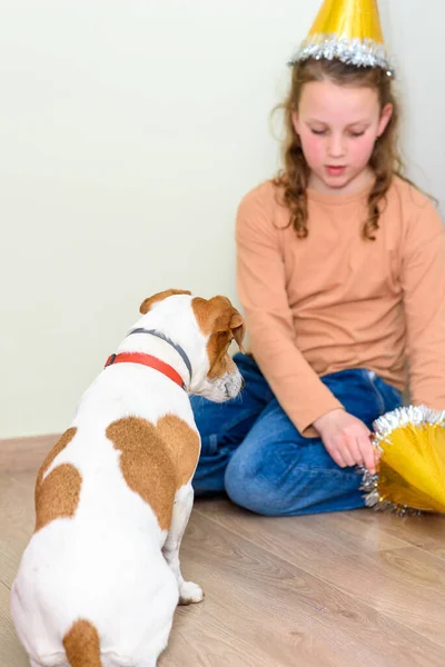 Liten flicka leker med sin hund i ett hem. — Stockfoto