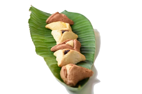 Galletas o galletas caseras judías de Hamantaschen en el fondo blanco de la hoja de palma. — Foto de Stock