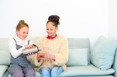 Sağlık bilinci açık genç kız tekrar kullanılabilir termostan tekrar kullanılabilir fincana çay dolduruyor. Dünyayı değiştirmeye çalışan gençler..