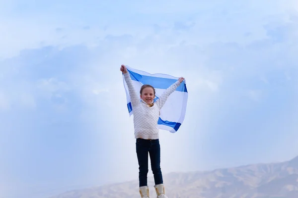Маленька патріотична дівчинка з прапором Ізраїлю на синьому тлі.. Стокова Картинка