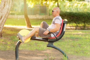 Yaşlı adam spor salonunda spor malzemeleriyle çalışıyor..