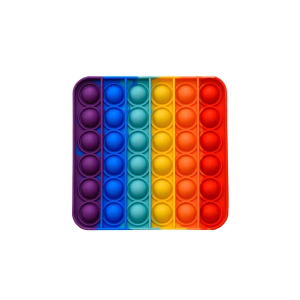 Das bei Kindern beliebte Mohn-neue Fidget-Spielzeug hilft ihnen, sich zu konzentrieren. Rainbow Pop it Fidget Toy isoliert auf weiß. — Stockfoto