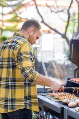 Genç Sakallı Adam Barbeküde Et Döndürüyor.