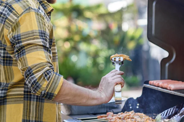 Anonimowy mężczyzna Flipping mięsa na grillu. — Zdjęcie stockowe
