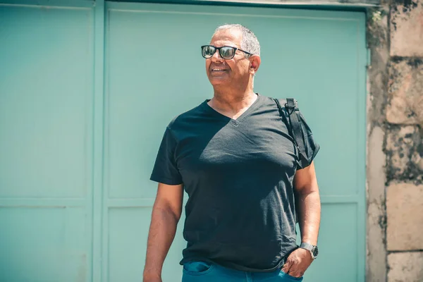 Подорож старшим способом життя. Портрет дорослого чоловіка з сонцезахисними окулярами та рюкзаками, подорожі на міських канікулах . — стокове фото