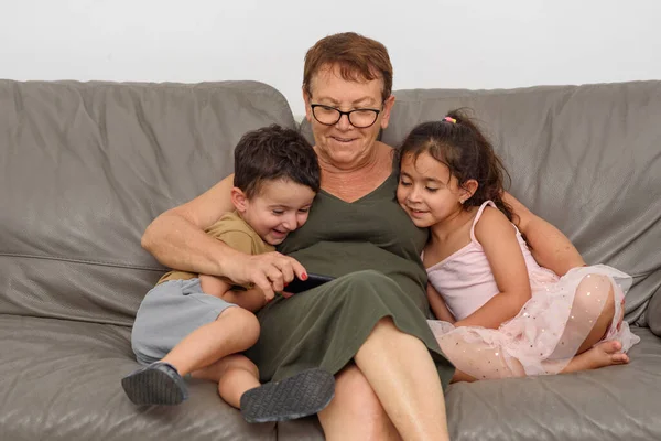 Glückliche Kinder lächeln am Telefon mit der Großmutter. — Stockfoto