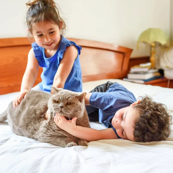 Bambini felici con il loro animale domestico sdraiato sul letto. — Foto Stock