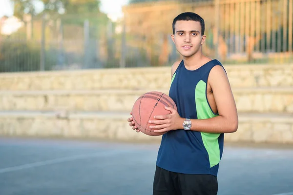 Basketballspieler hält einen Ball. Glücklich Teen Holding Basket Ball. — Stockfoto