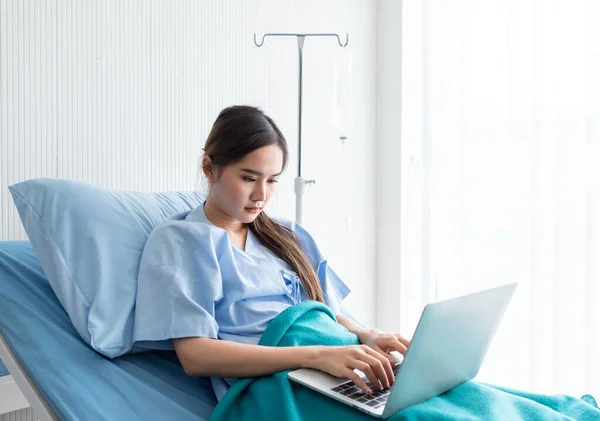 아시아인젊은 병실의 배경에서 침대에 컴퓨터로 일하는 시간에 일하는 — 스톡 사진