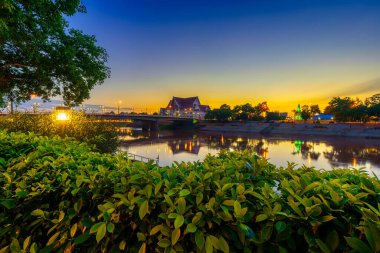 Doğal akşam Wat Phra Si Rattana Mahathat 'ın önünde halk arasında Wat Yai olarak da anılır Nan Nehri ve Phitsanulok, Tayland' da gün batımında yürümek için park.