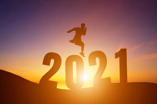 stock image Happy New Year 2021, Silhouette a man handsome  jumping feels happy moving morning sunrise over the horizon background, Health and Happy new year concept.