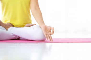 Asyalı kadınların yakın plan çalışmaları yoga çalışmaları sarı elbise giymeleri ve meditasyon sağlık yaşam tarzı ve sağlık konseptini spor salonunda uygulamaları, yer kopyalamaları.