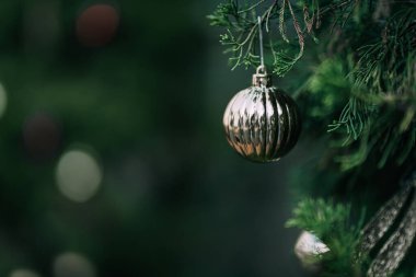 Mutlu Noel 'ler, renkli baloları, hediye kutularını ve Noel arkaplanındaki yeşil Noel ağacı dekorasyonunu Noel ve yeni yıl boyunca kutlayın..