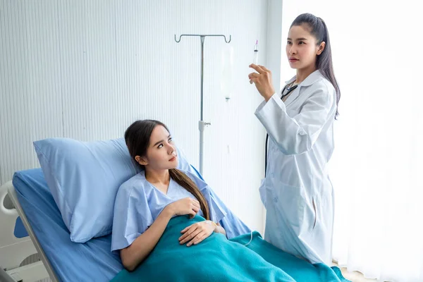 アジアの若いです女性医師とともに注射器でアジアの若い女性患者へベッドの上でより良い治癒のために部屋の病院の背景 — ストック写真