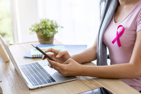 戴头巾粉红缎带的女性癌症患者在接受化疗治疗后 在家里的智能手机和笔记本电脑上写信息 医学概念 — 图库照片