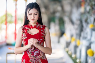 Çin Yeni Yıl Festivali için Tayland 'daki Çin tapınağında geleneksel Çin cheongsam madalyası takan Asyalı güzel bir genç kız portresi.