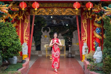 Çin Yeni Yıl Festivali için Tayland 'daki Çin tapınağında geleneksel Çin cheongsam madalyası takan Asyalı güzel bir genç kız portresi.