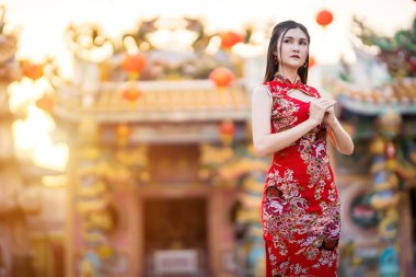 Çin Yeni Yıl Festivali için Tayland 'daki Çin tapınağında geleneksel Çin cheongsam madalyası takan Asyalı güzel bir genç kız portresi.