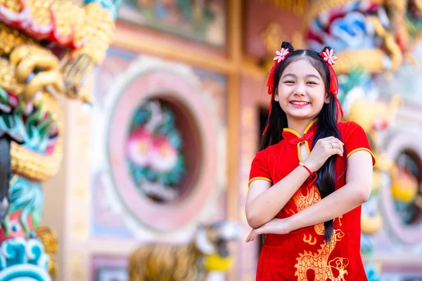 肖像画の美しい笑顔かわいいアジアの女の子は中国の神社で中国の旧正月の祭りのために赤い伝統的な中国のChongsam装飾を着て — ストック写真
