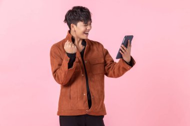 Başarılı ve ekspres bir Asyalı. Tablet kullanan yakışıklı genç bir adam. Yan gözlerinden aşk kamerasına bakıyor..