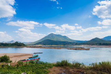 Mae Khong nehrinin Riverside manzarası ve limana park etmiş bir tekne, Tayland 'ın Chiang Khan şehrindeki Kaeng Khud Khu nehrinin dağ manzarası..