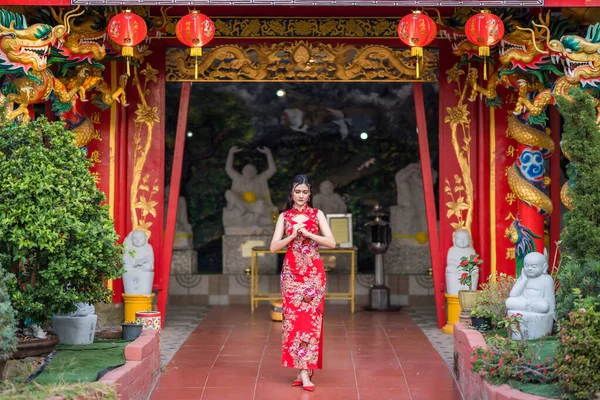 Asian woman wearing red traditional Chinese cheongsam decoration hold paper lanterns with the Chinese text Blessings written on it Is a Fortune blessing compliment decoration for Chinese New Year