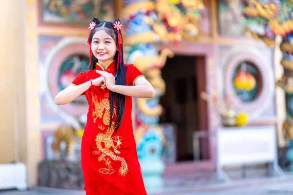 肖像画の美しい笑顔かわいいアジアの女の子は中国の神社で中国の旧正月の祭りのために赤い伝統的な中国のChongsam装飾を着て — ストック写真